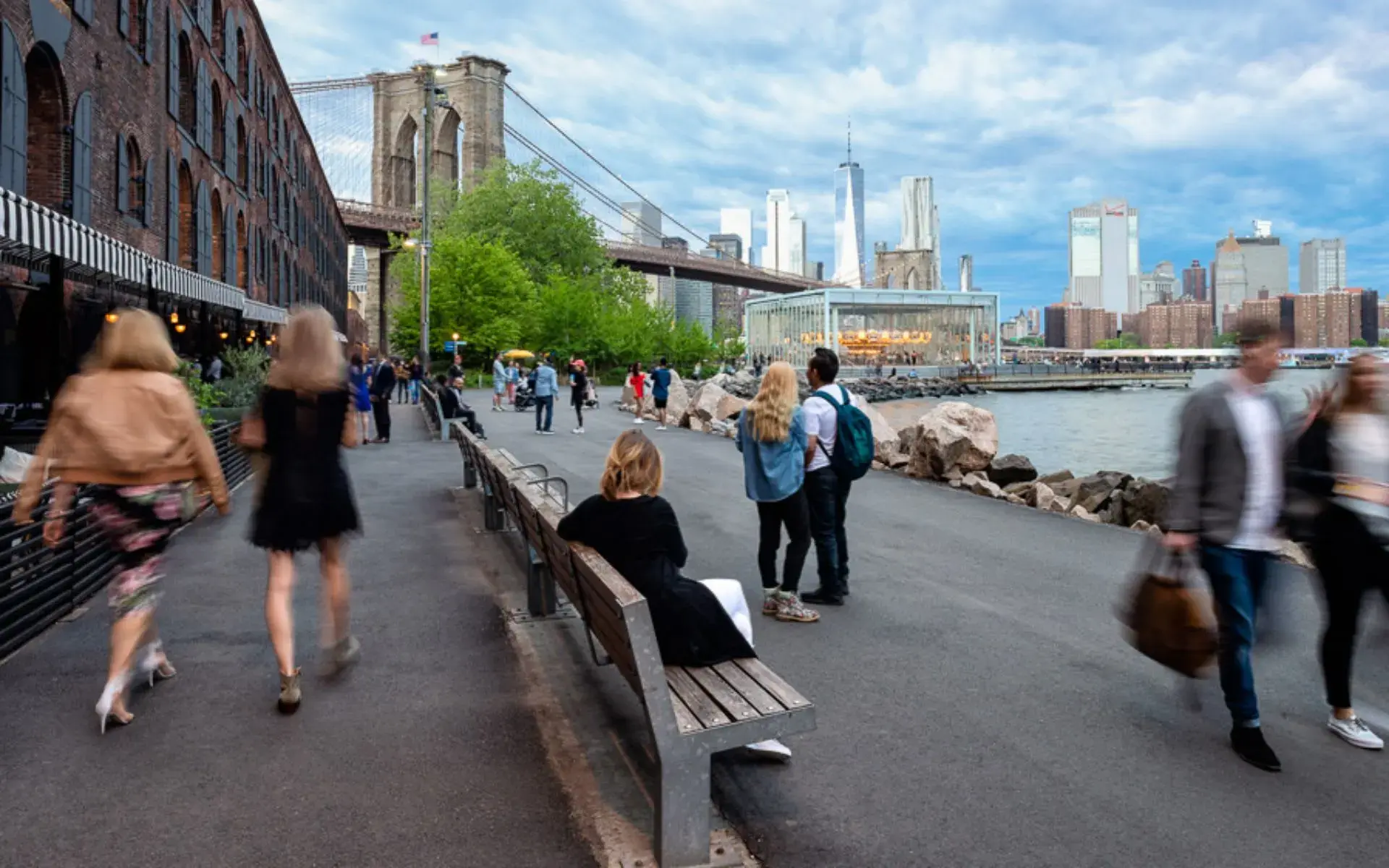 Scenic waterfront walkway in Brooklyn with views of the NYC skyline.