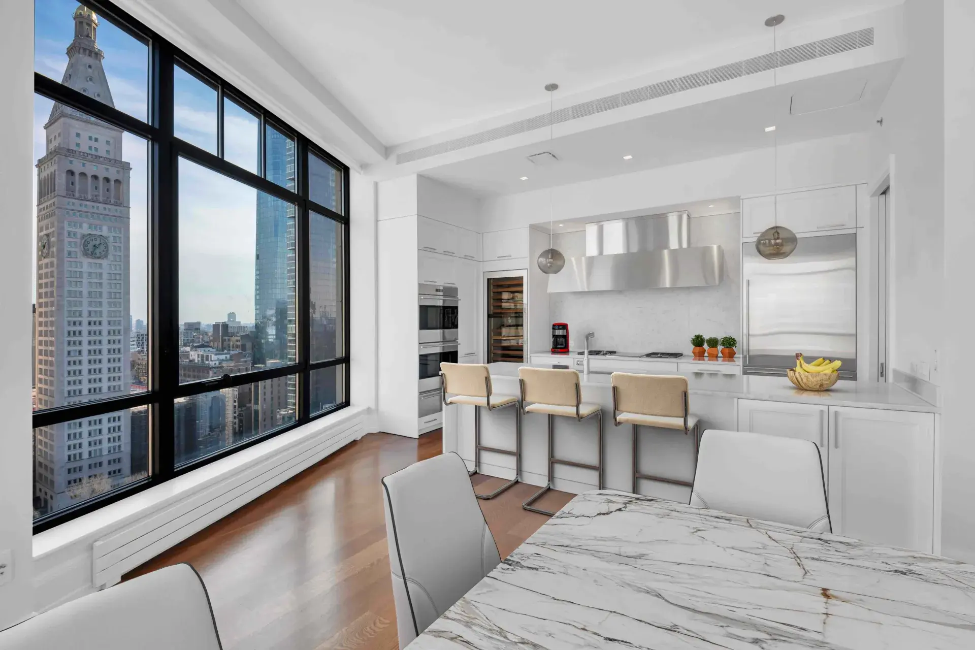 Modern white kitchen with floor-to-ceiling windows and city skyline views.