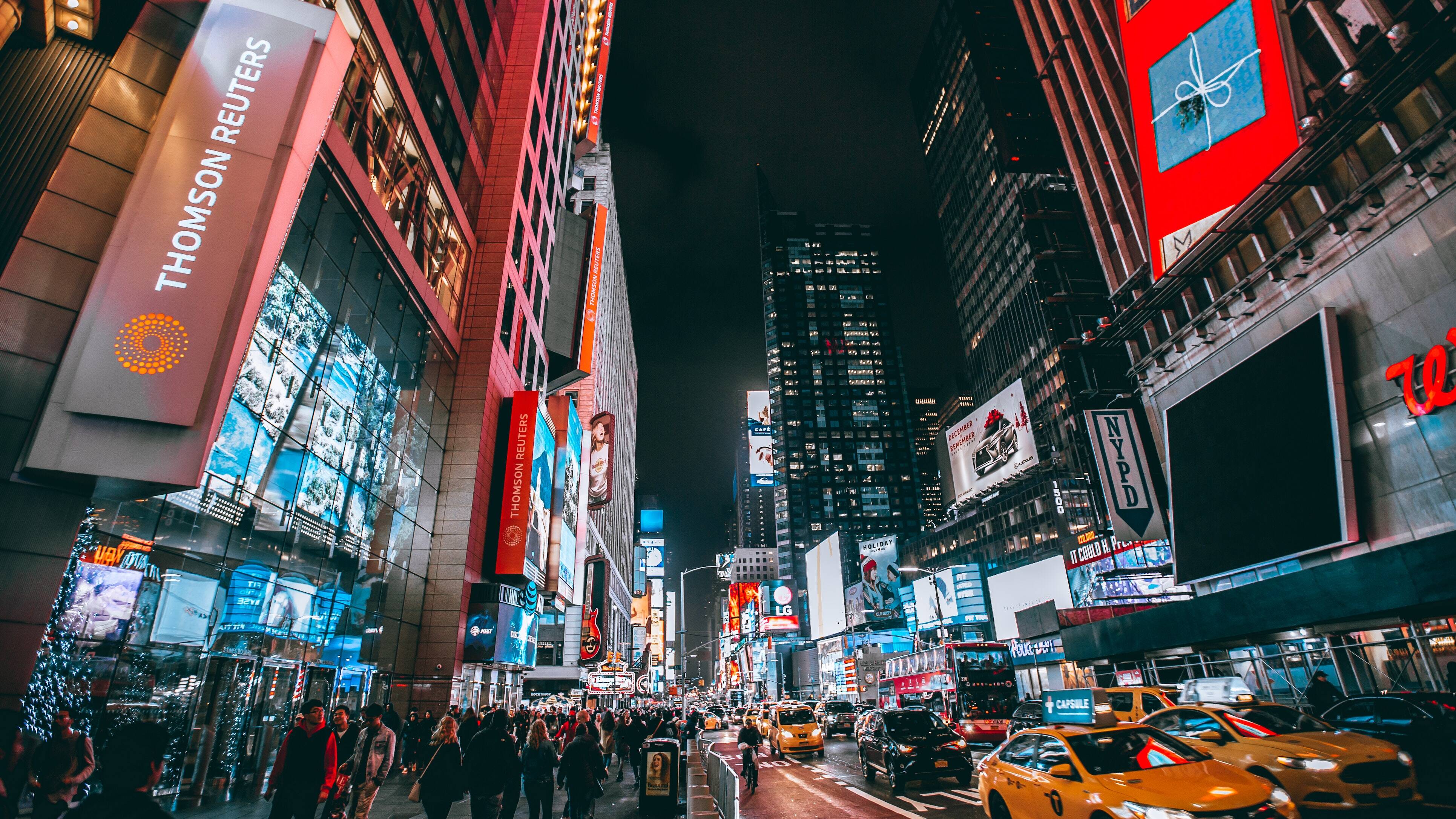 A bustling nighttime scene of Times Square with vibrant lights and busy streets.