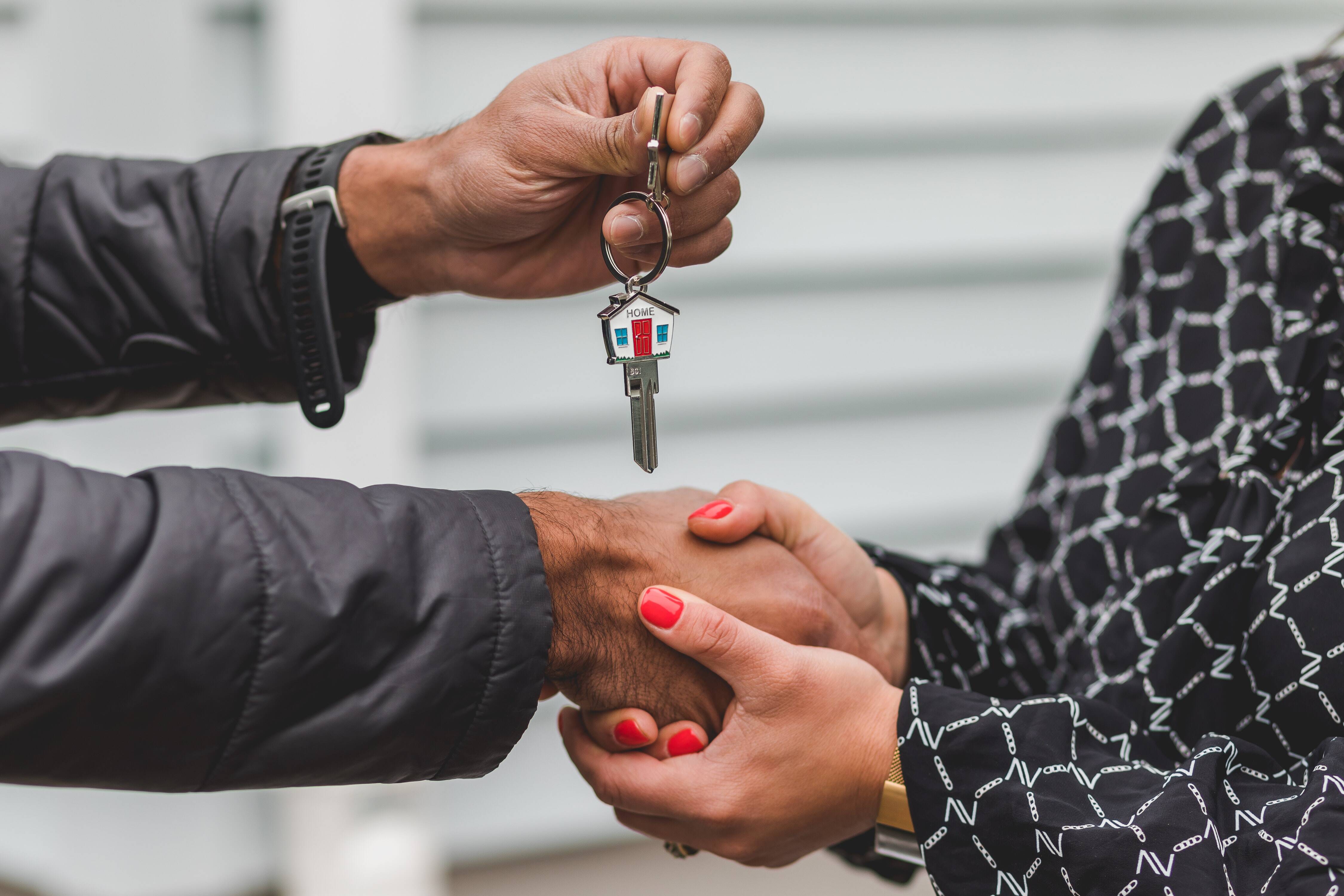 Real estate agent handing over house keys to a new homeowner.