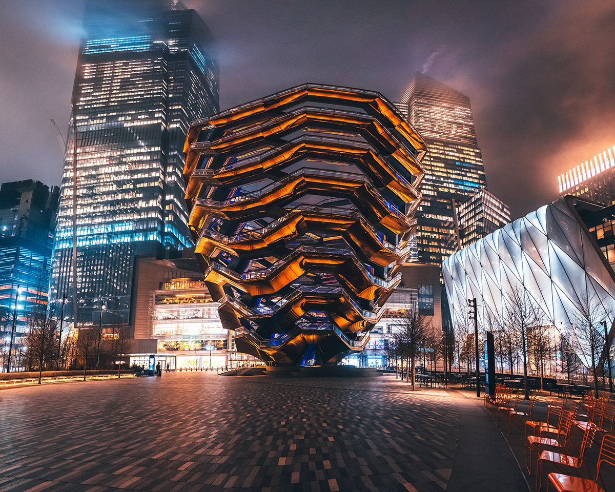 A striking nighttime view of The Vessel, highlighting its futuristic design and surrounding skyscrapers.