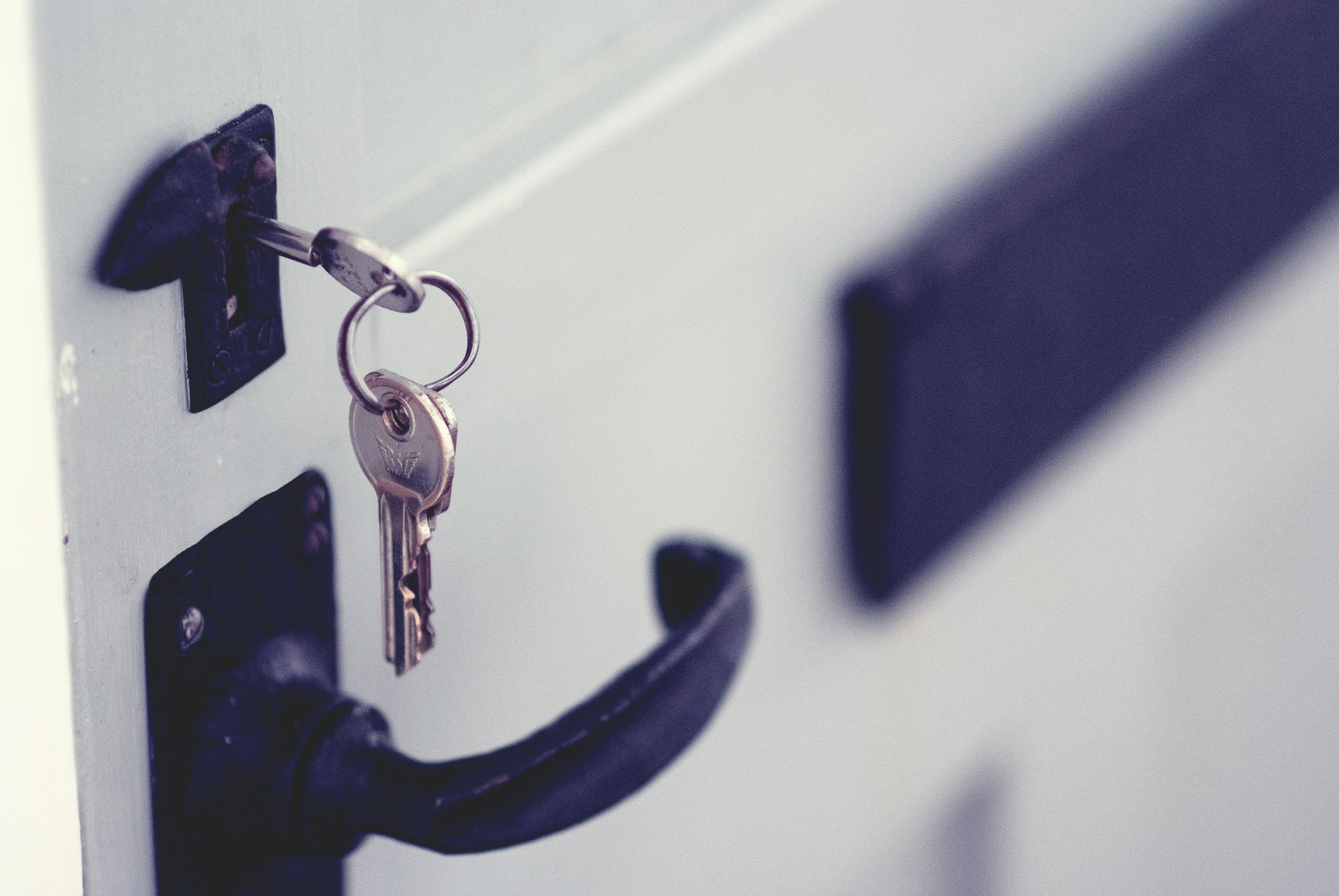 Close-up of house keys inserted in a door lock, symbolizing rental security and property management.