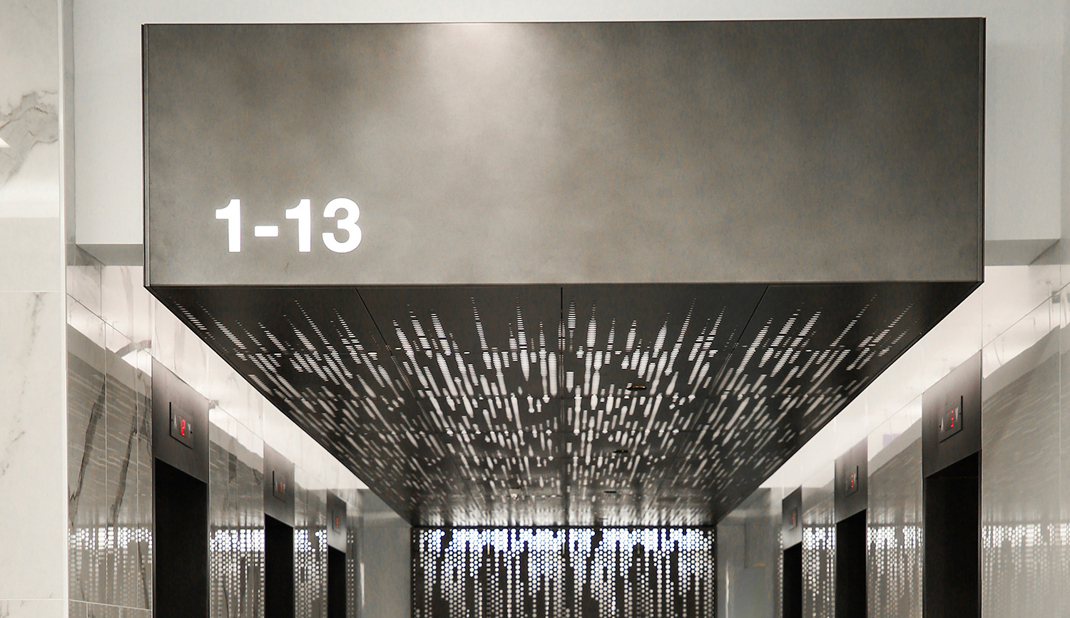 Modern lobby entrance with artistic ceiling design and room number indicators.