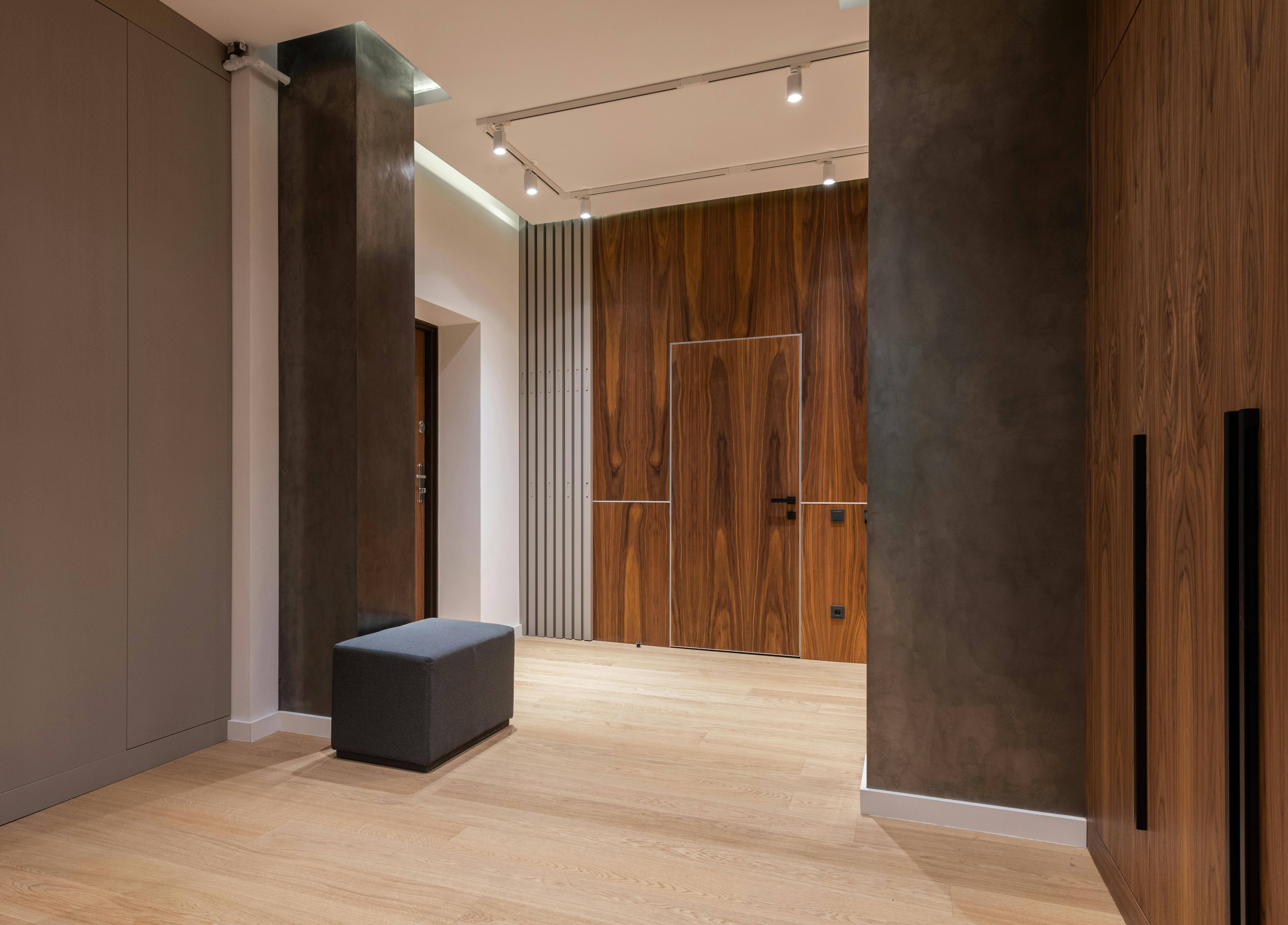 A modern residential building lobby with wooden paneling and minimalist design, showcasing upscale living.