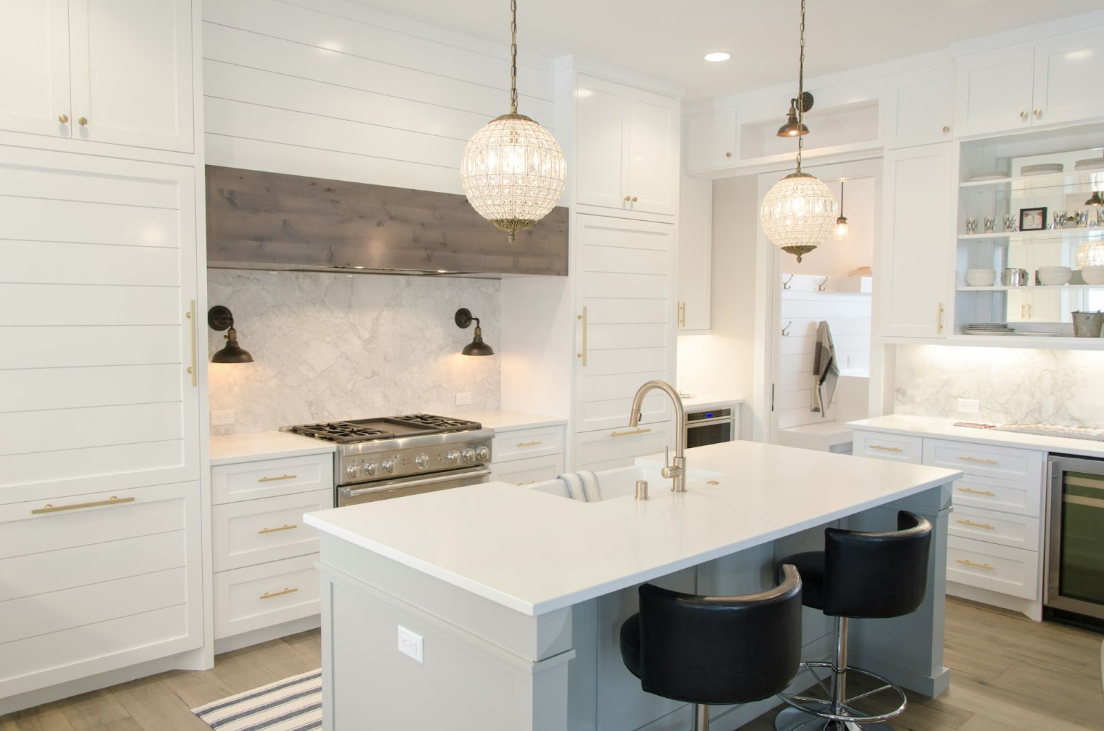 Interior of an open concept kitchen with white finishes and stainless steel appliances