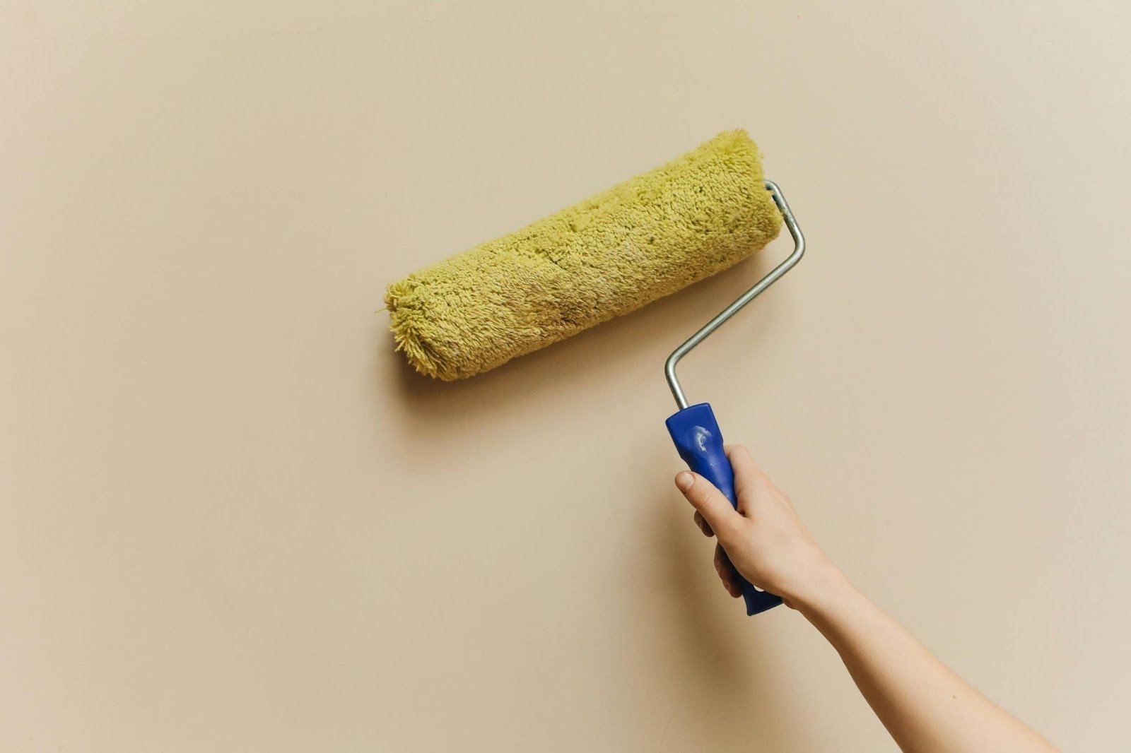 Photo of a person painting an interior wall